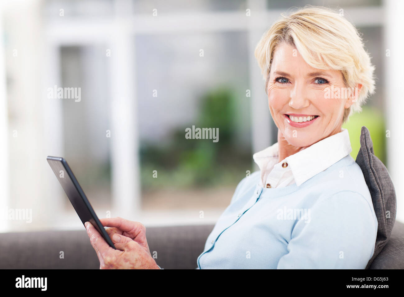 elegant middle aged woman using tablet pc at home Stock Photo