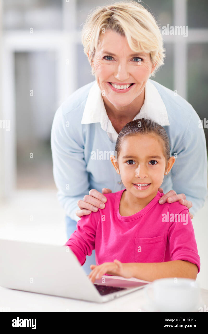 pretty grandmother and cute granddaughter using notebook computer at home Stock Photo