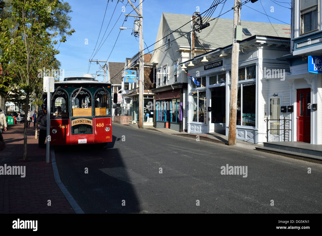 Provincetown Cape Cod street scenic with shops and  tour trolley bus. USA Stock Photo