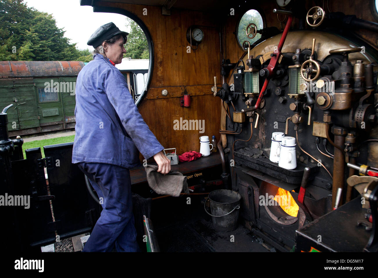 A female engine driver working the footplate of a steam on