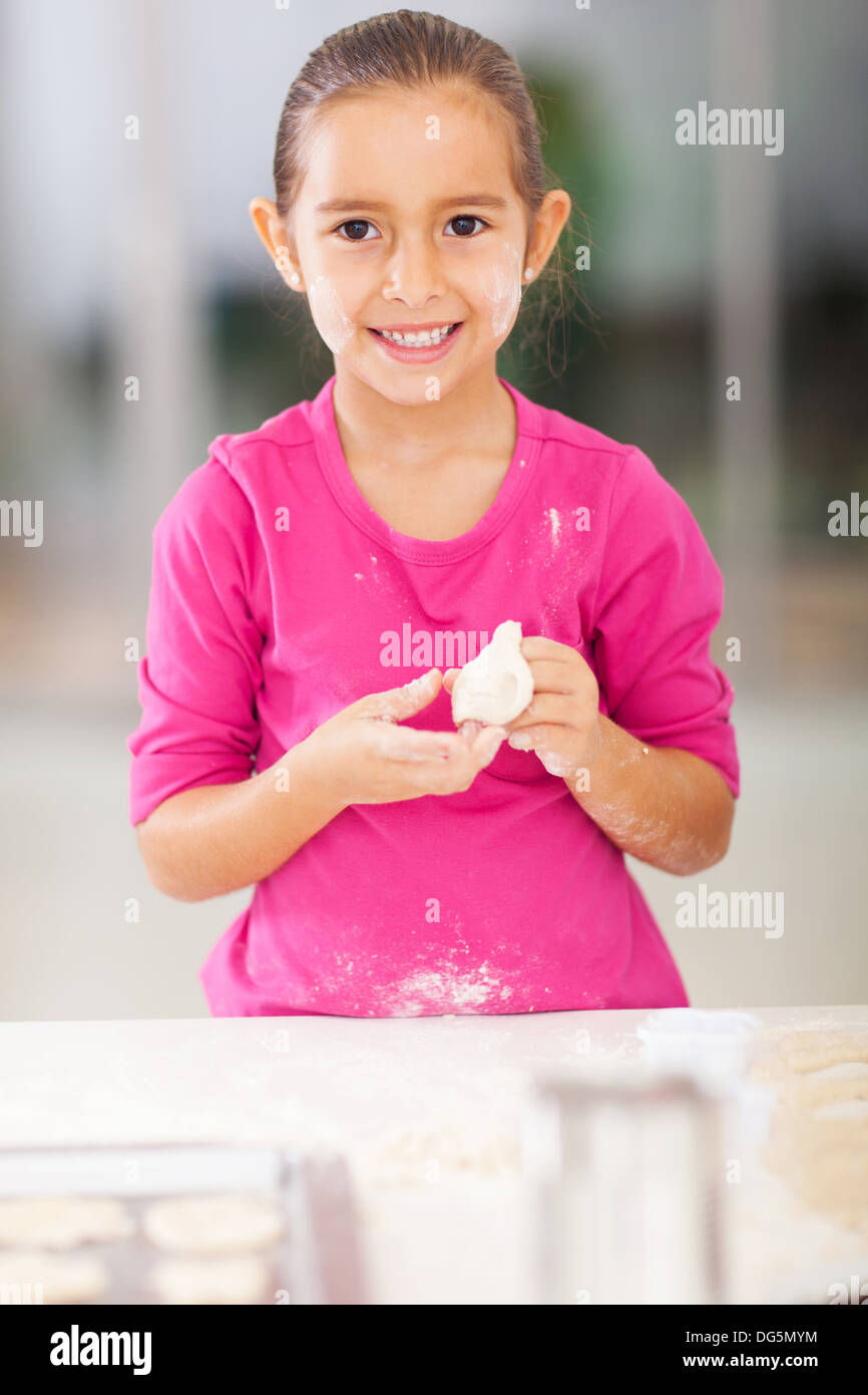 portrait of pretty girl playing with bread dough in kitchen Stock Photo
