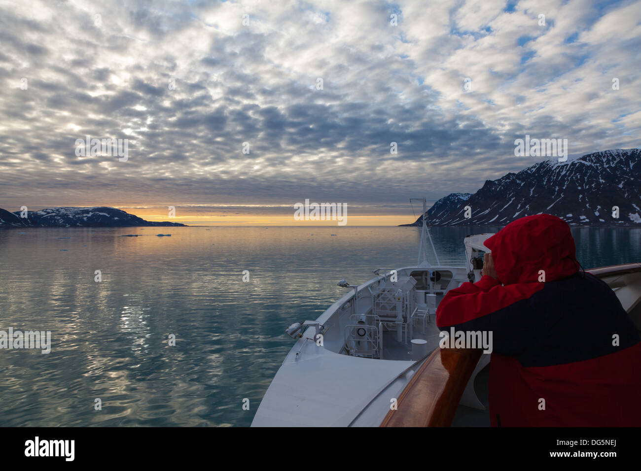 Expedition ship passenger photographing the sunset at King's Fjord, Svalbard Stock Photo