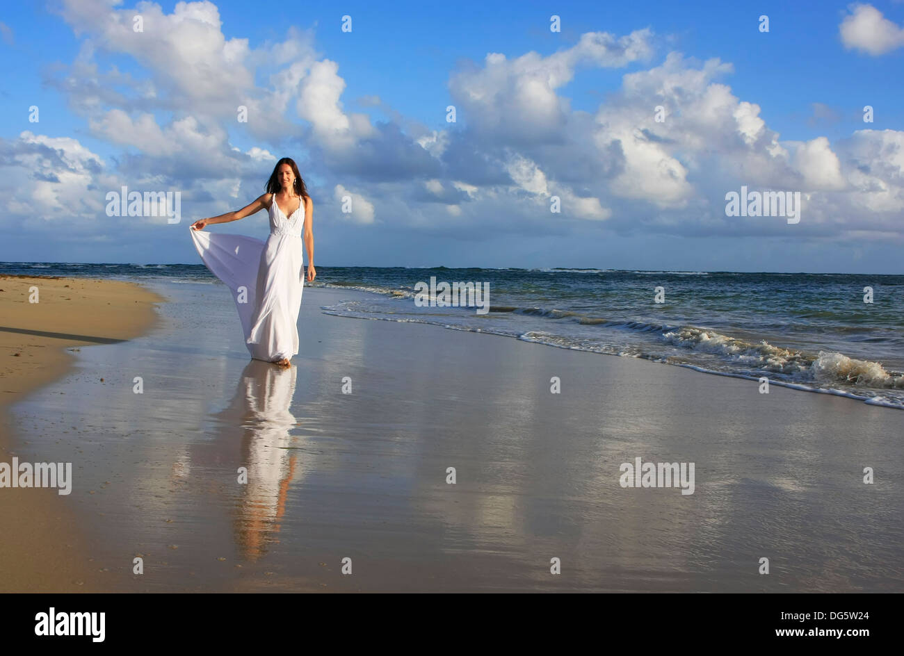 Young woman in white dress on a beach Stock Photo