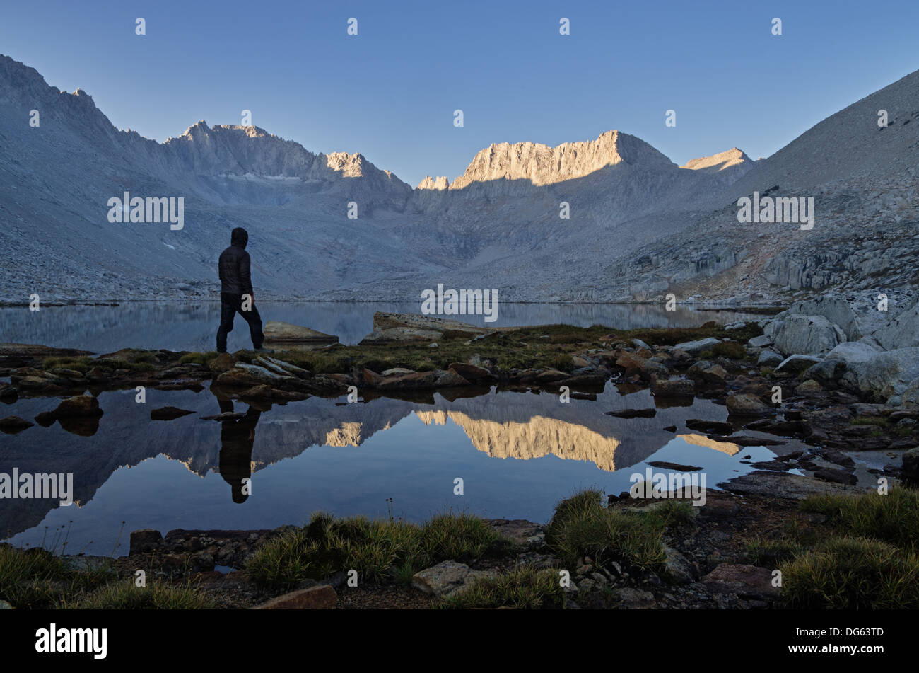 a man looking at the mountain morning view over Snow Lake to Mount Mills in the Sierra Nevada Mountains Stock Photo