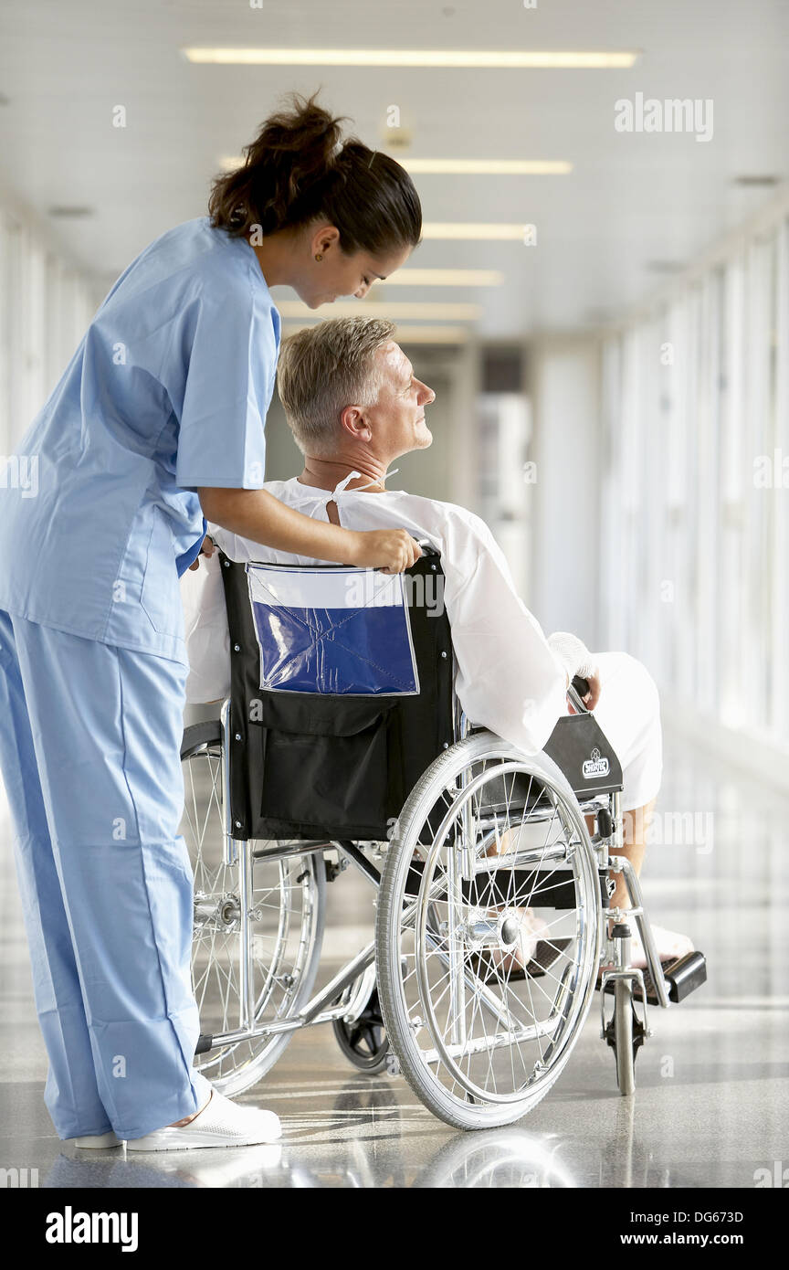 Nurse pushing patient in wheelchair Stock Photo Alamy