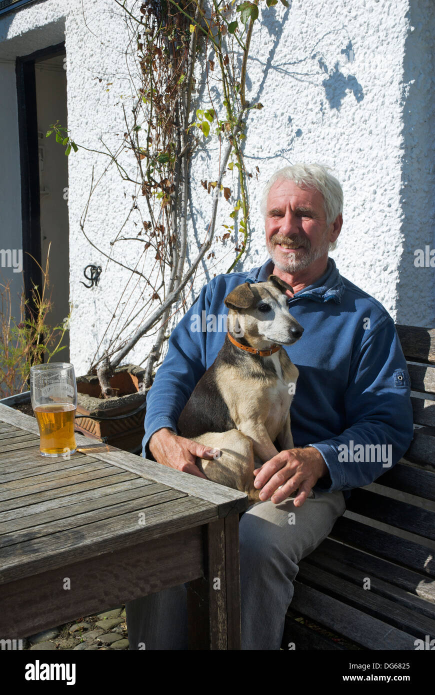 Man and dog outside the Blacksmiths Arms, Broughton Mills, Lake District National Park, Cumbria, England UK Stock Photo