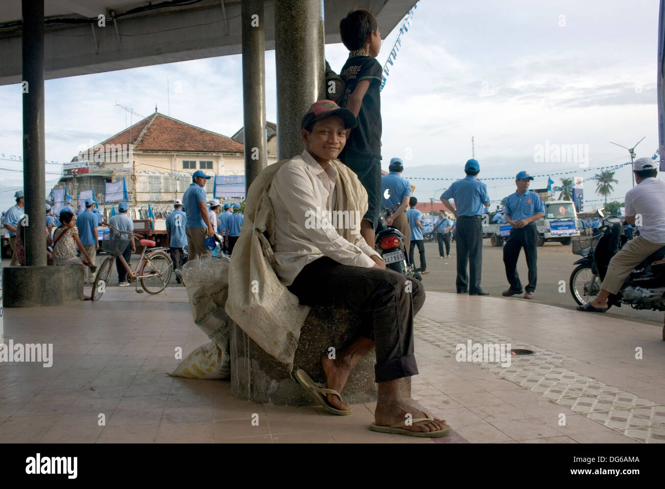 A street scavenger is relaxing with a sack he fills with recyclable material during a rally for the CPP Kampong Cham, Cambodia. Stock Photo