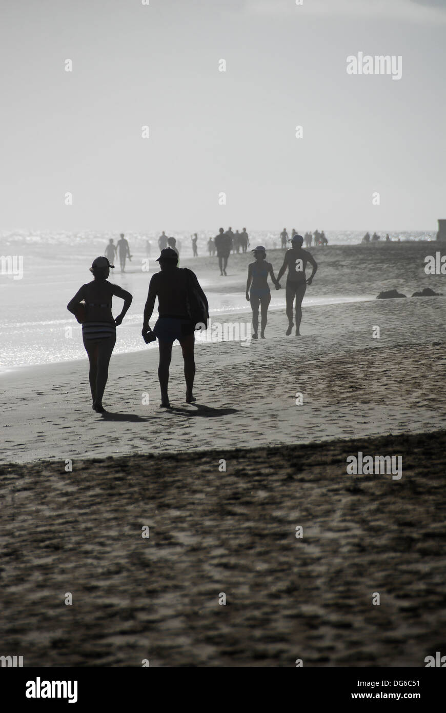 Couples walking and holding hands on beach Stock Photo