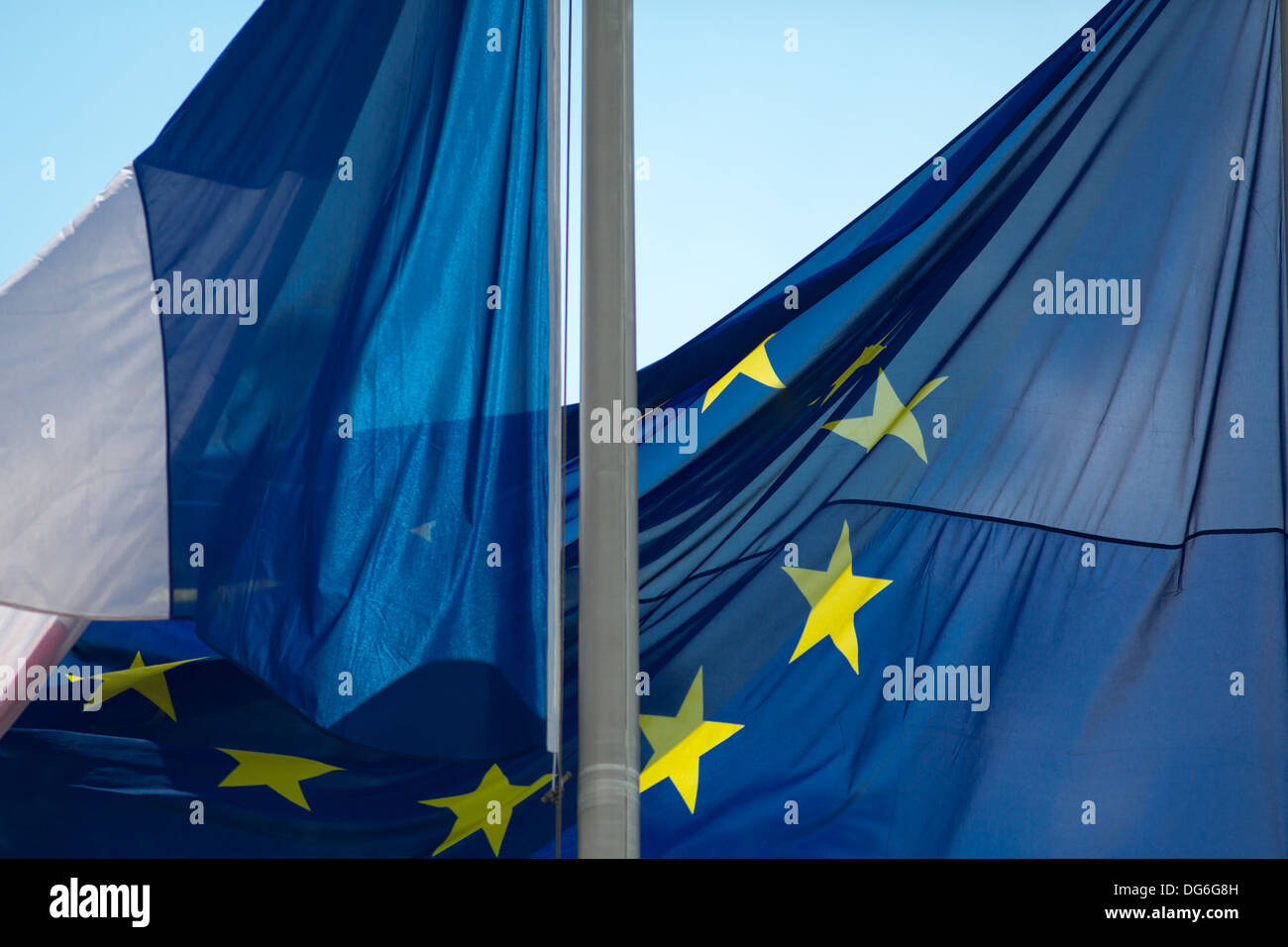 French flag and European EU flag wave in bright sun against a blue sky Stock Photo