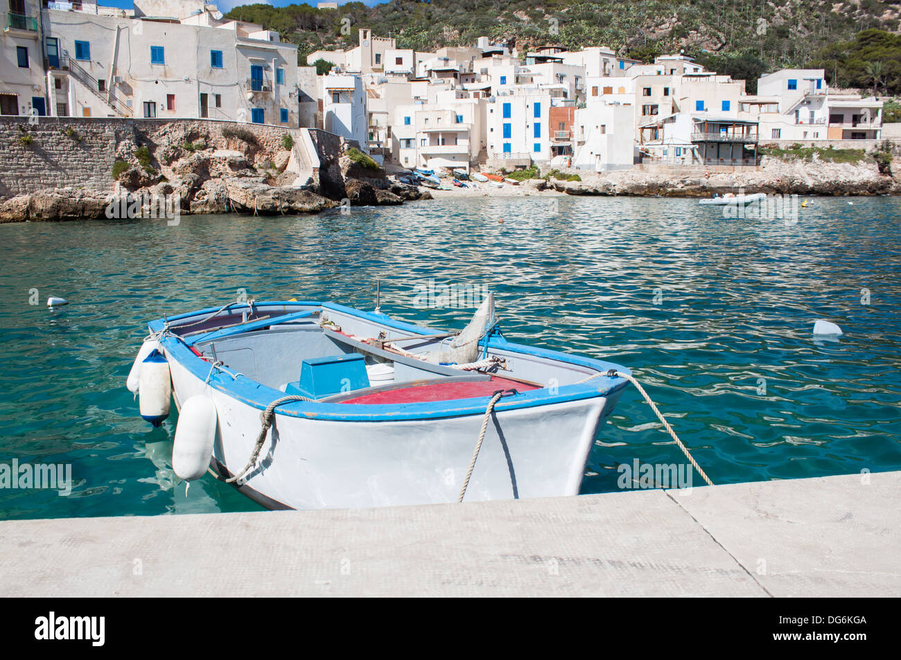 'fishing boat' rowboat  sea Levanzo island water pier dock coast houses buildings summer old wooden nobody Stock Photo
