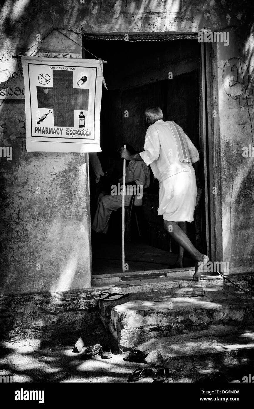 Rural Indian man walking into pharmacy at Sri Sathya Sai Baba mobile outreach hospital clinic. Andhra Pradesh, India. Monochrome Stock Photo