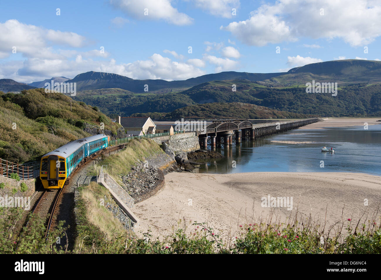 Barmouth, Wales, UK, 15 October 2013.  Bright sunshine, clear skies and a temperature of around 17 degrees made for a beautiful end-of-season day. A train on the Cambrian Coast line crosses the Barmouth Bridge, Credit:  atgof.co/Alamy Live News Stock Photo
