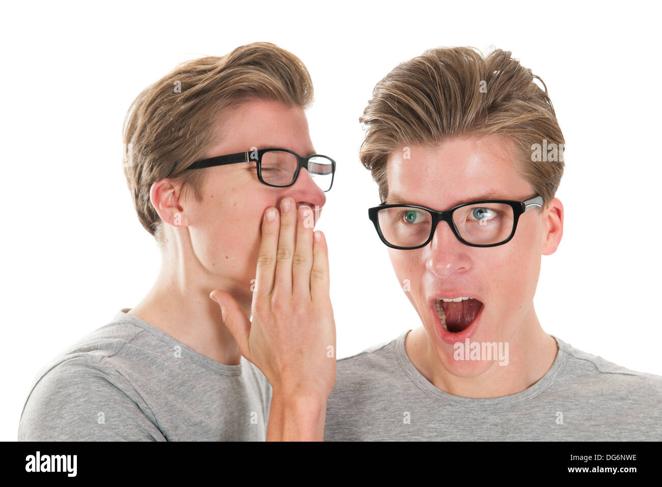 Identically adult male twins whispering in ear isolated over white ...