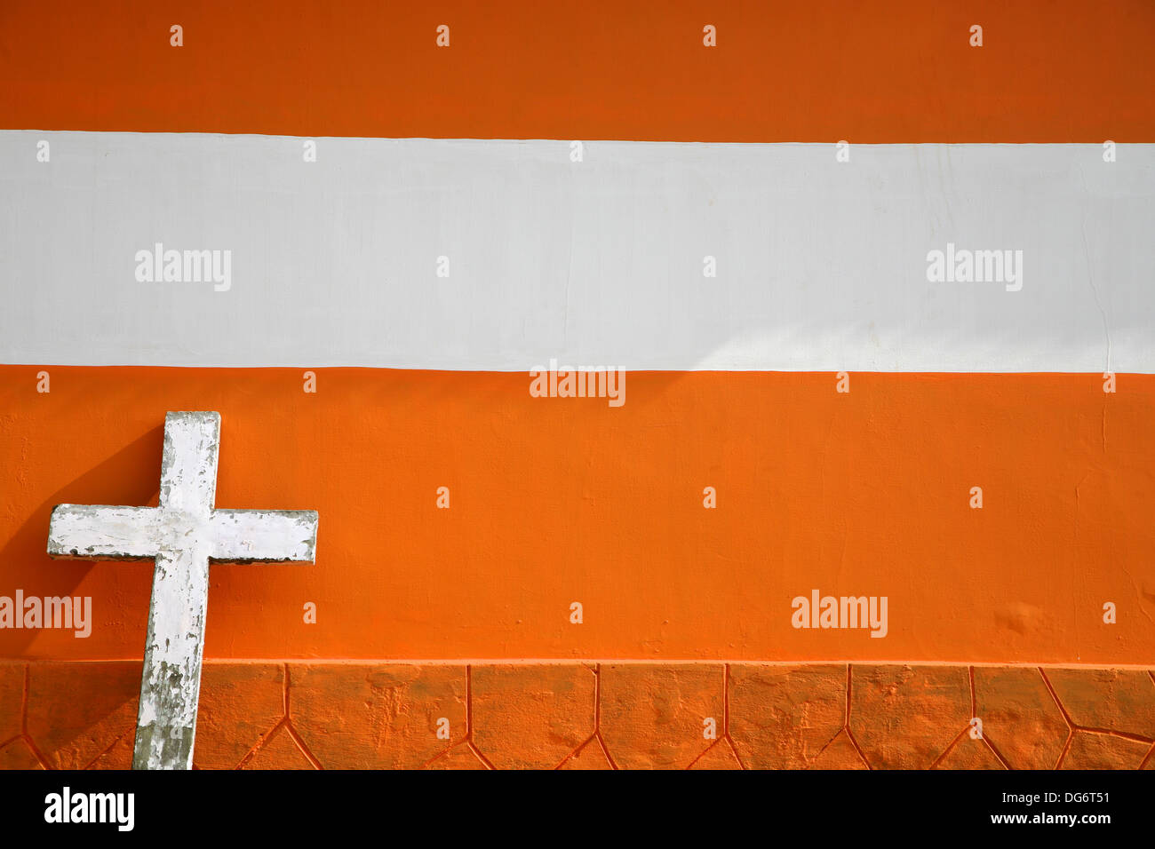 White Cross on Urban orange Brick Church in Kerala, India Stock Photo