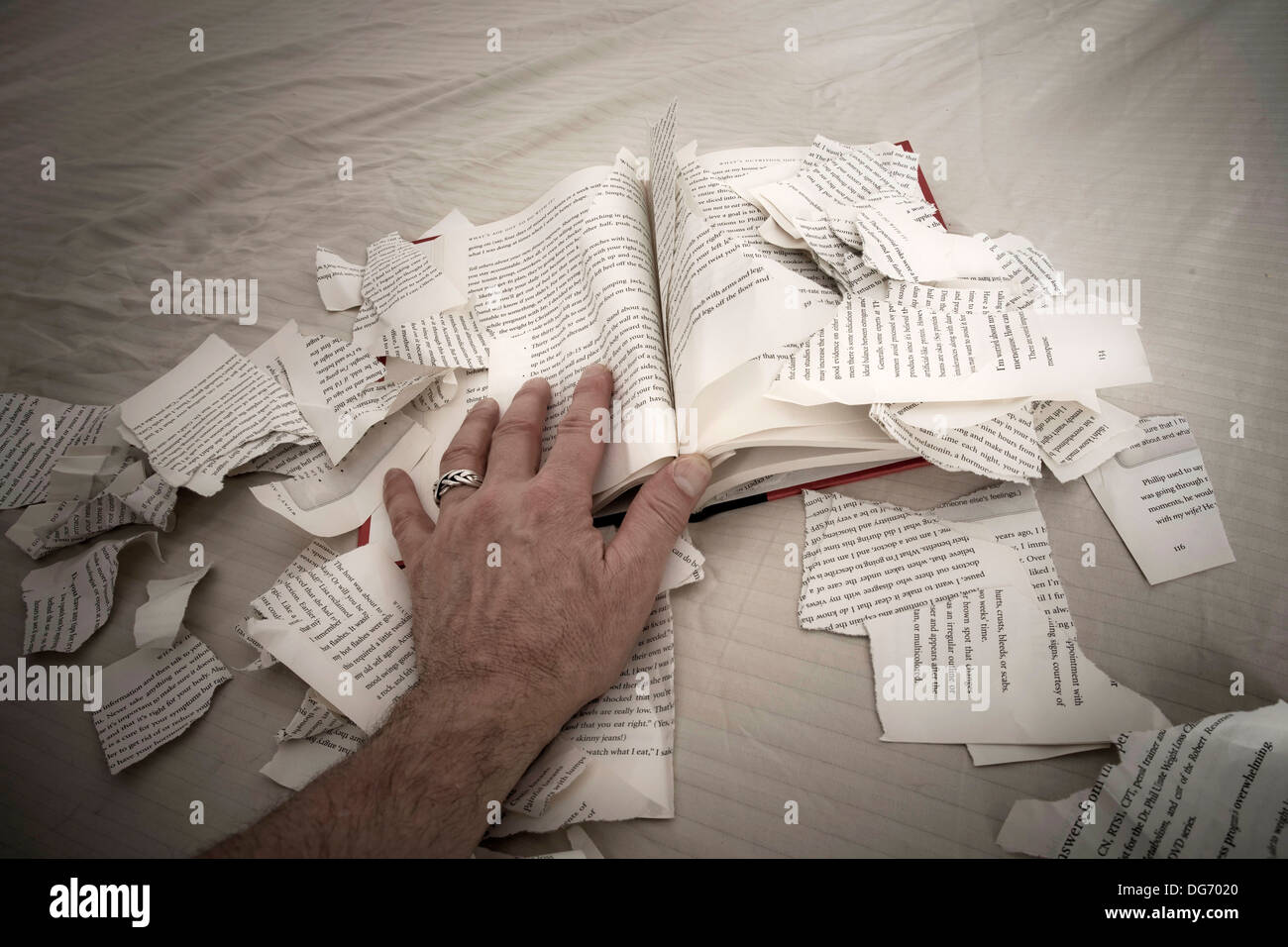 Man´s hand on a book with ripped-up pages Stock Photo - Alamy