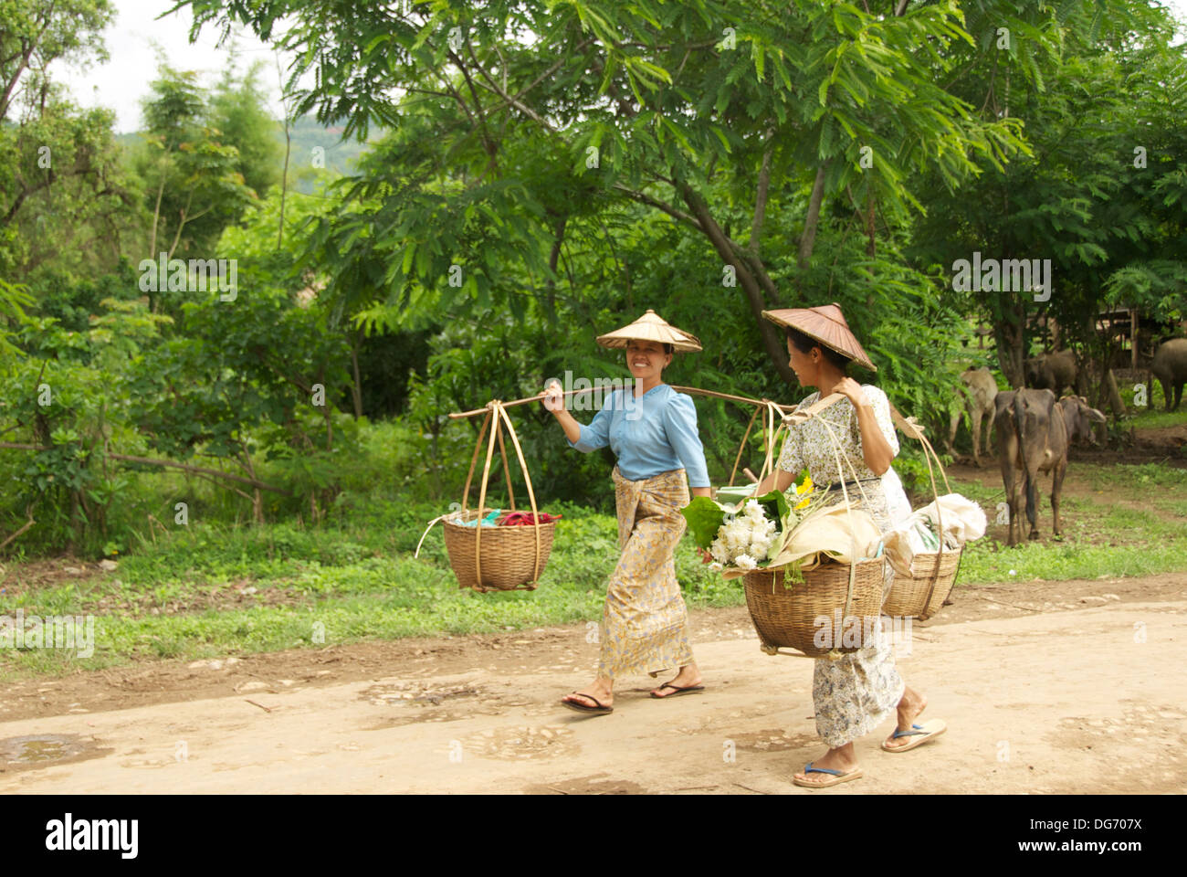 Burmese women carrying baskets on the way to a market Stock Photo