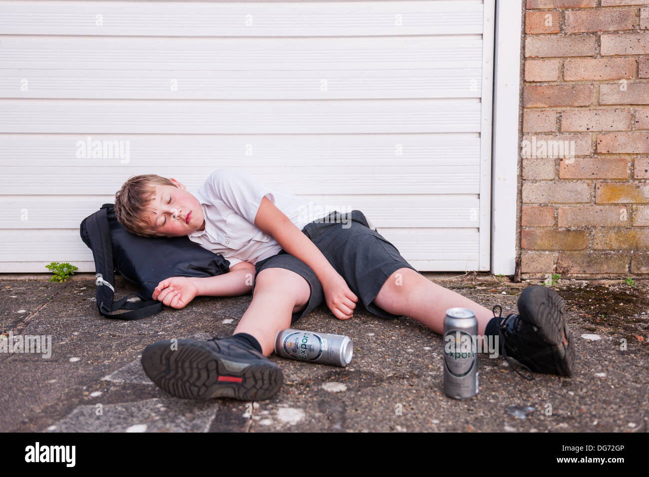 A boy of 10 in his school uniform drinking lager alcohol showing the