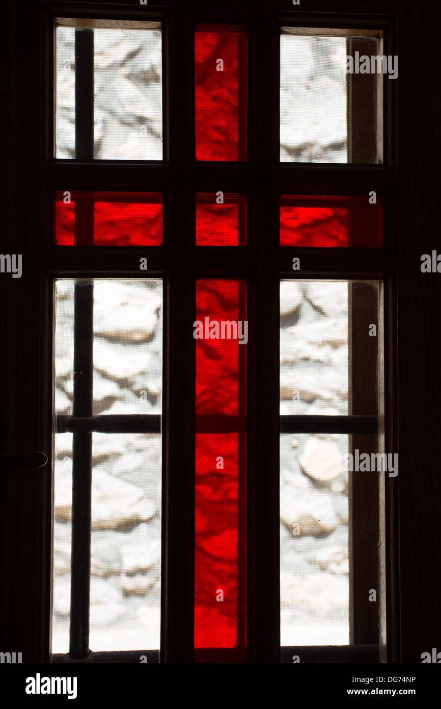 Stained window with red cross in a church in Santorini, Greece 2013. Stock Photo