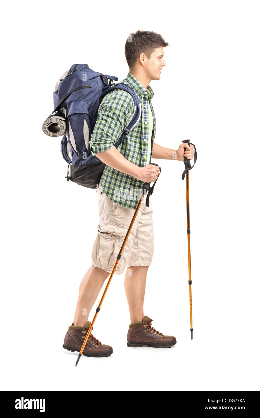 Full length portrait of a hiker with backpack and hiking poles walking ...