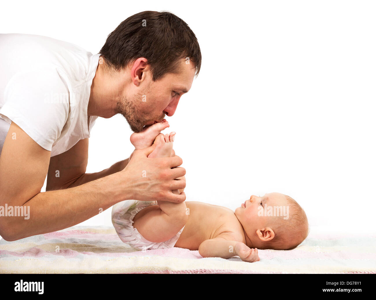 Young caucasian father kissing feet of his baby son Stock Photo