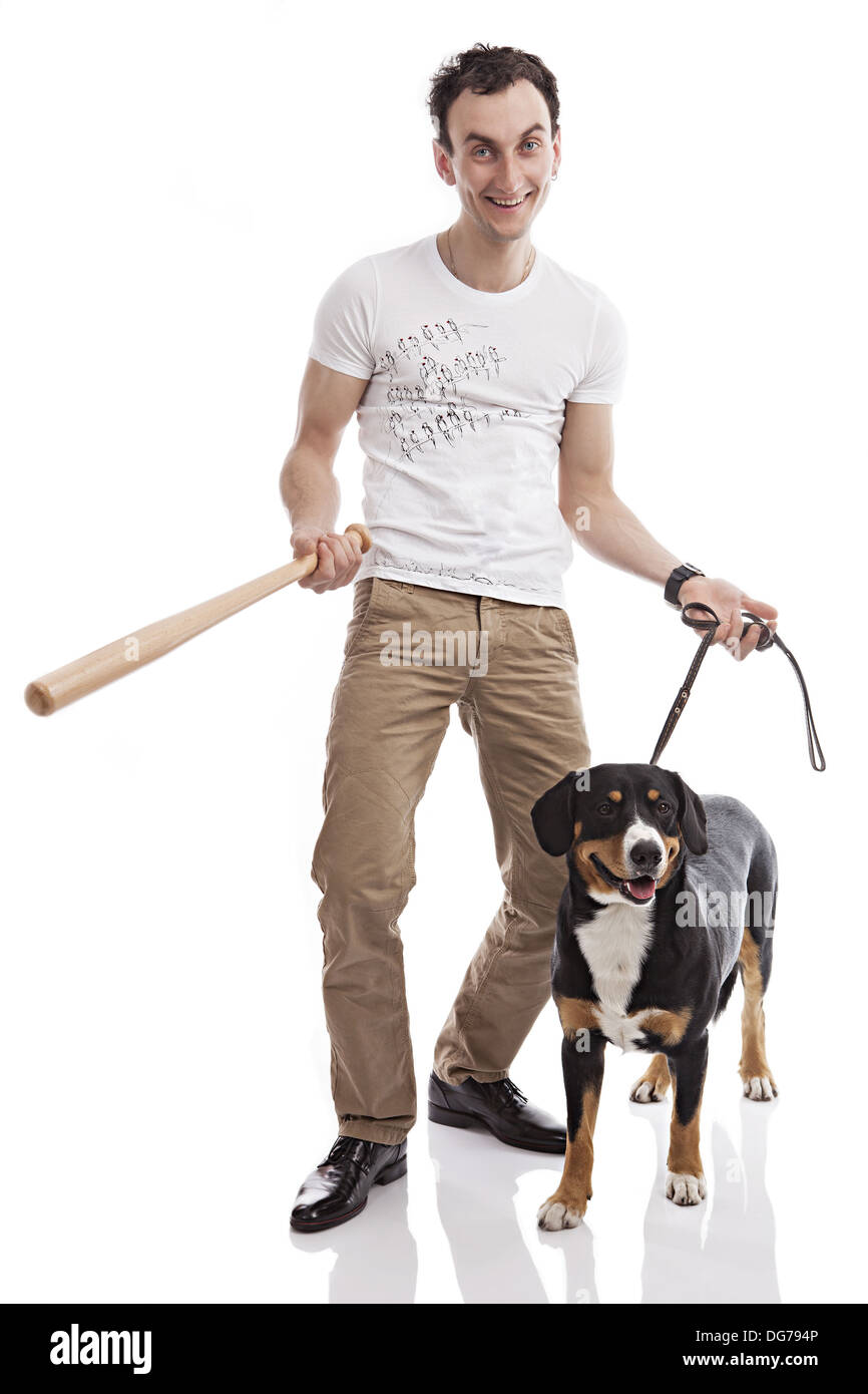 Young Caucasian man holding bat, with Entlebucher Sennenhund dog Stock Photo