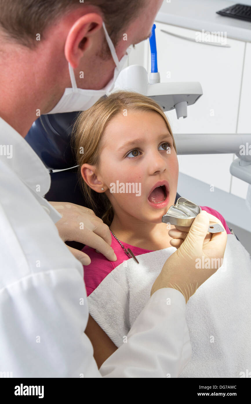 Dental practice, dentistry. Young girl at a dentist treatment Stock