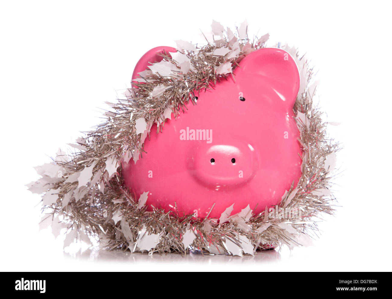 Piggy bank wrapped in Christmas tinsel studio cutout Stock Photo