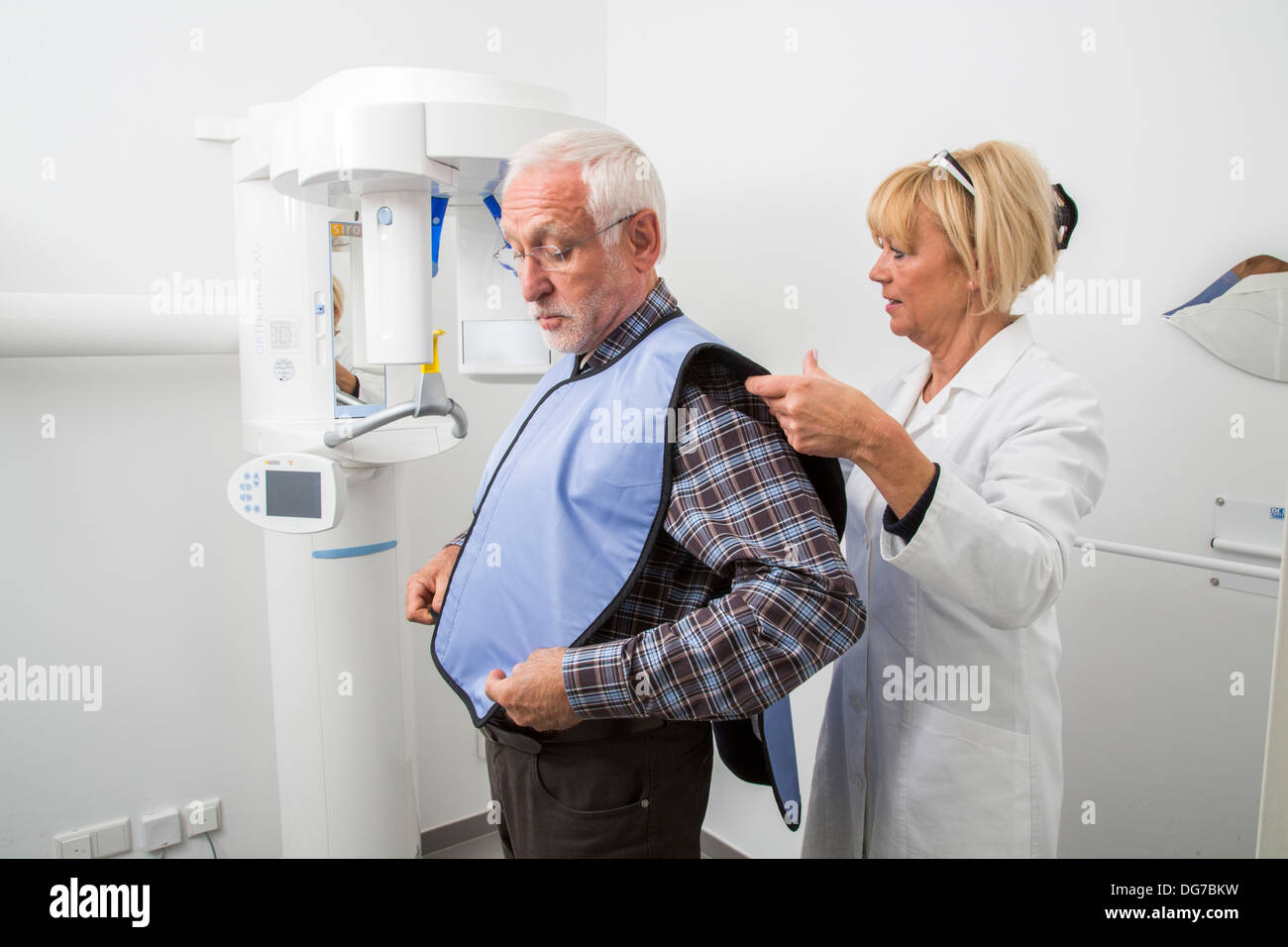 Dental practice, dentistry.Patient prepared for the X-ray of the teeth. Lead vest as radiation protection. Stock Photo