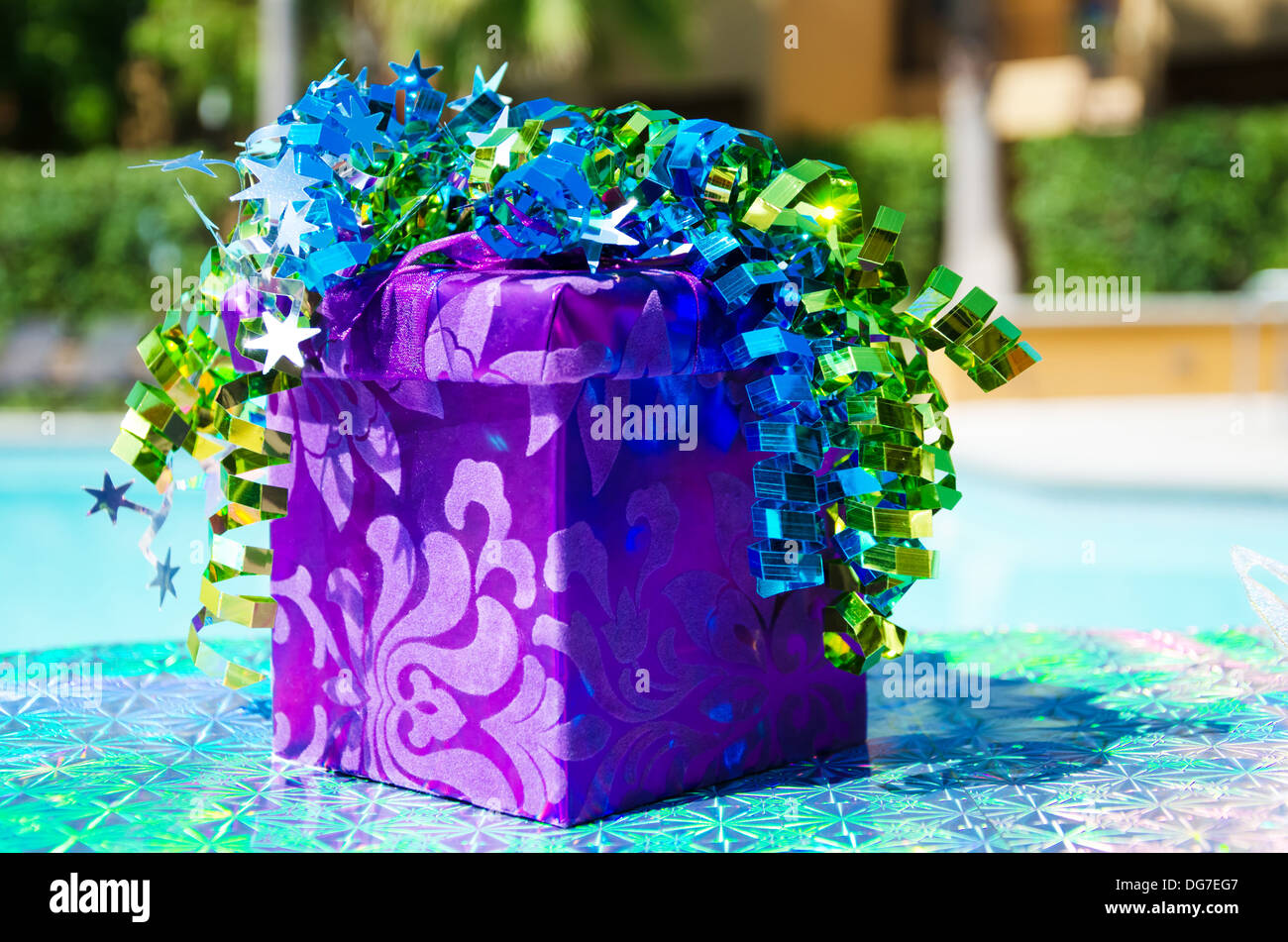 Purple Gift box with ribbon by the swimming pool Stock Photo - Alamy