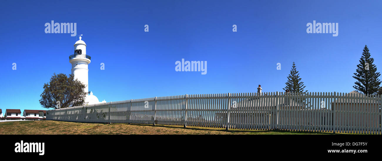 Stitched Panorama, Macquarie Light House in panoramic image with white picket fence in foreground, blue clear sky. Stock Photo