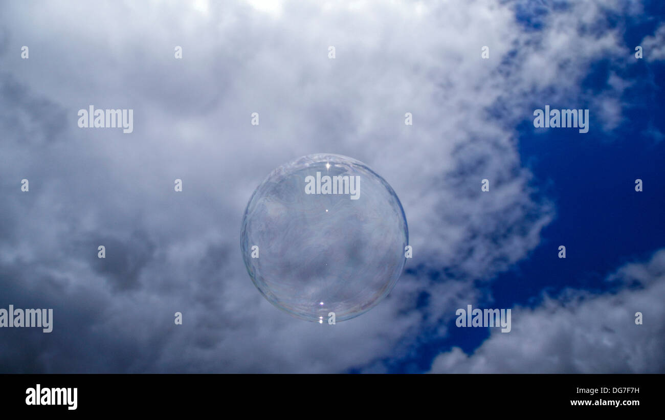 Soap Bubble against blue sky with puffy white clouds. Stock Photo