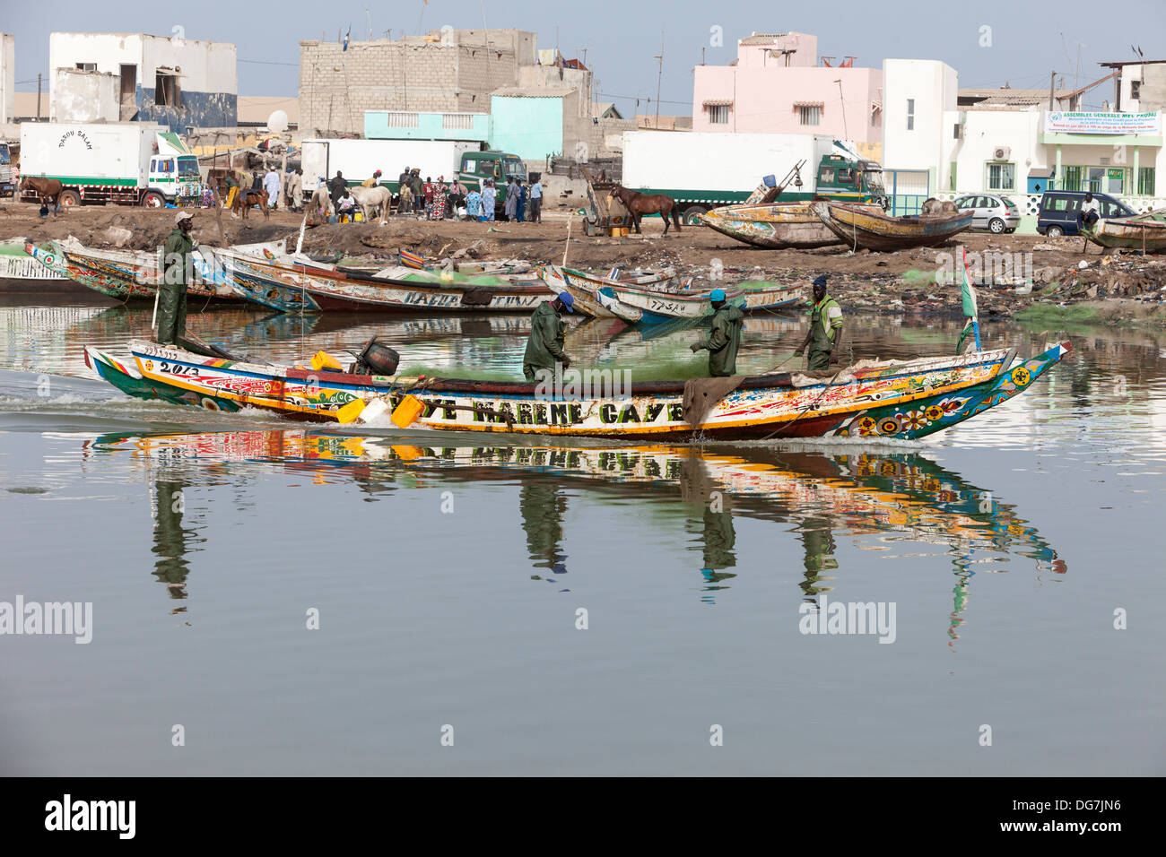 Senegal, Saint Louis. Fishermen Head to Sea while Refrigerated Trucks Line up to Carry Fishermen's Catch to Inland Markets. Stock Photo