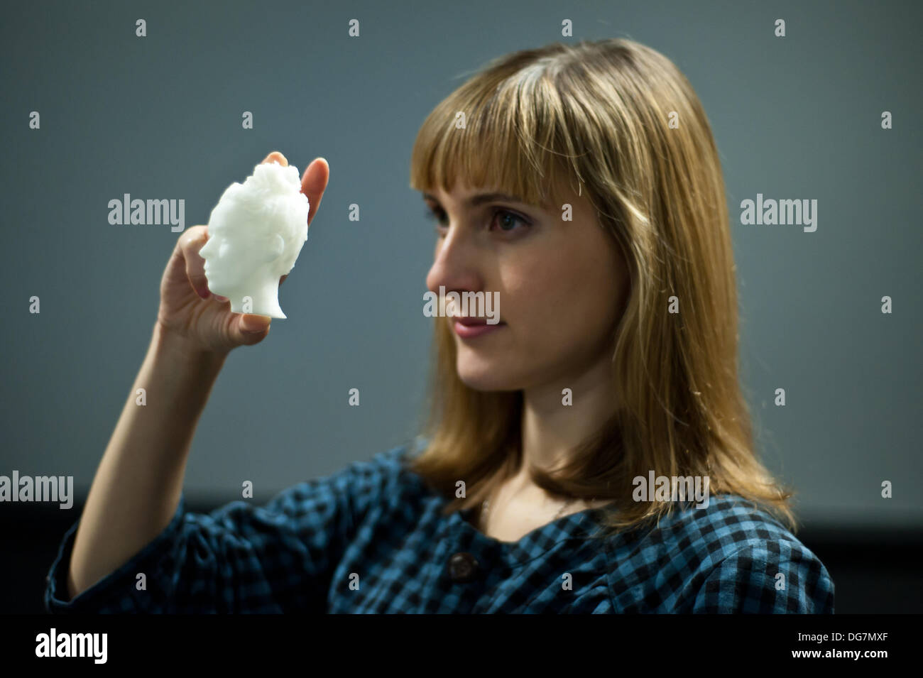 London, UK – 10 October 2013: Kathy Boyce holds on small 3D printed head made of ABS at the Inition, Everything in 3D demo studio in Shoreditch, East London. Stock Photo