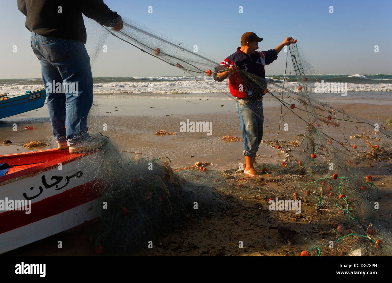 Tunez:Hammamet. Beach.Fishermen checking a net Stock Photo