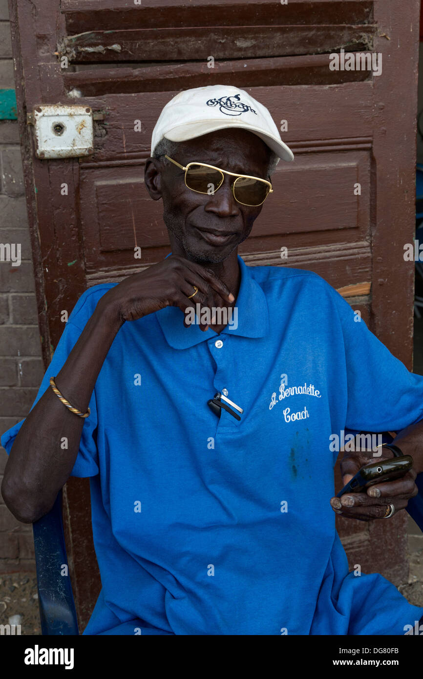 Senegal, Saint Louis. Caretaker with his Cell Phone at the Abandoned Railway Station, no longer in use. Stock Photo