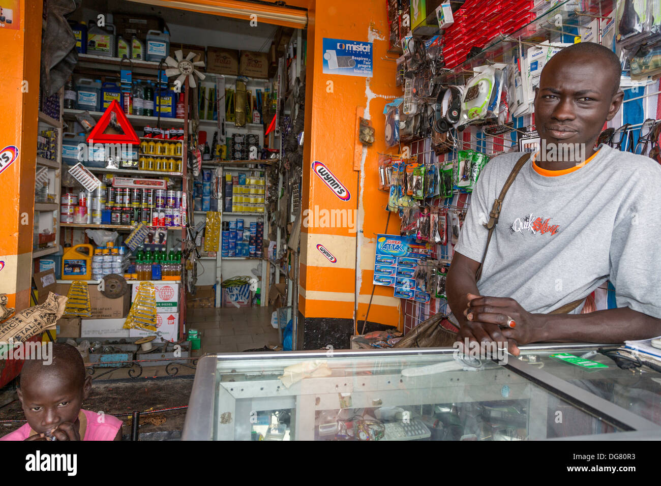Senegal, Saint Louis. Shopkeeper Selling Auto Spare Parts at Bus and Taxi Station. Stock Photo