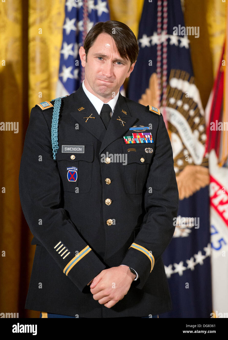 William Swenson, a former active duty Army Captain, who will be awarded the Medal of Honor for conspicuous gallantry, listens as United States President Barack Obama makes remarks in the East Room of the White House in Washington, DC on October 14, 2013. Captain Swenson accepted the Medal of Honor for his courageous actions while serving as an Embedded Trainer and Mentor of the Afghan National Security Forces with Afghan Border Police Mentor Team, 1st Battalion, 32nd Infantry Regiment, 3rd Brigade Combat Team, 10th Mountain Division, during combat operations in Kunar Province, Afghanistan on Stock Photo