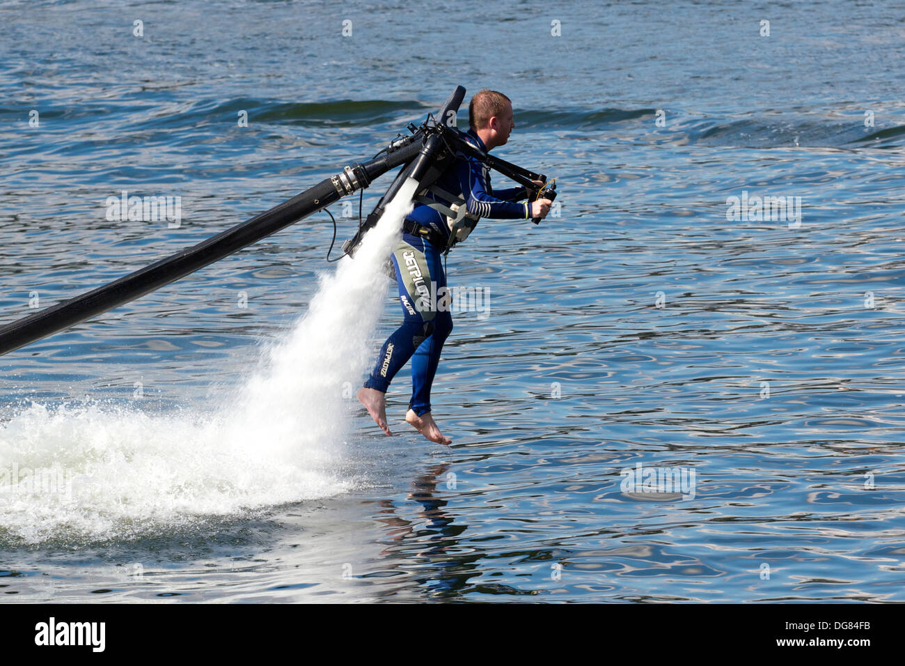 Man piloting a water powered jet pack (Jet Lev) at high speed Royal Victoria Dock London England Europe Stock Photo