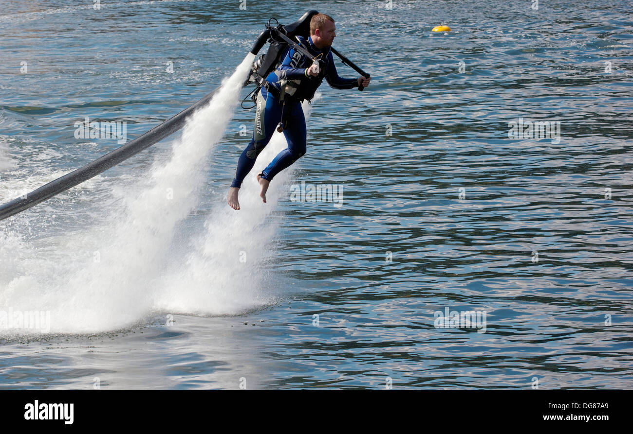 Man piloting water powered jet pack at high speed Royal Victoria Dock London England Europe Stock Photo