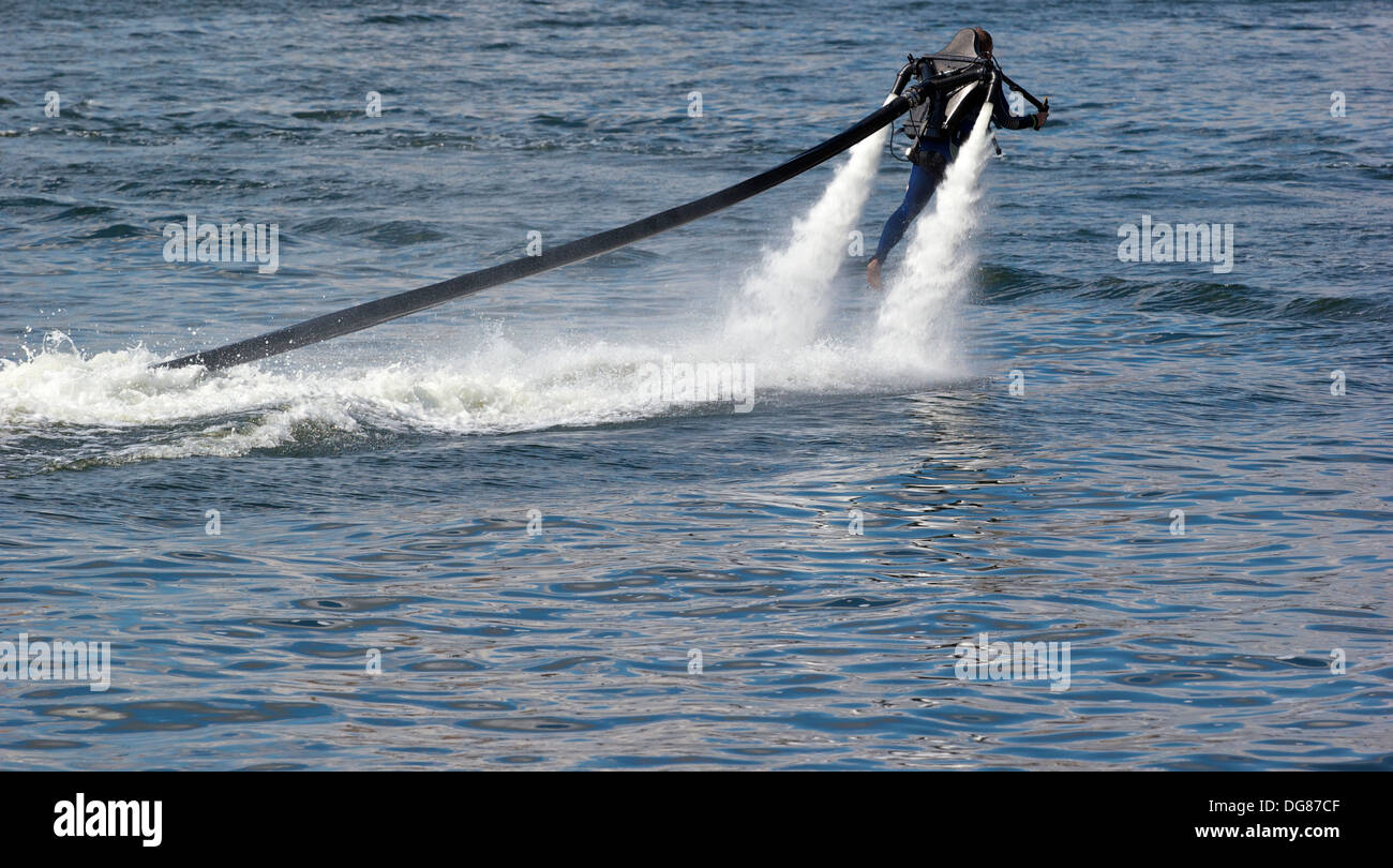 Man piloting a high pressure water powered jet pack (Jet Lev) Royal Victoria Dock London England Europe Stock Photo