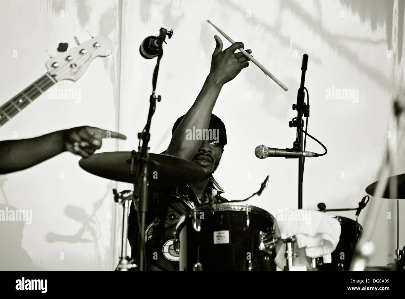 Drummer twirling drum stick silhouetted against back cloth Stock Photo