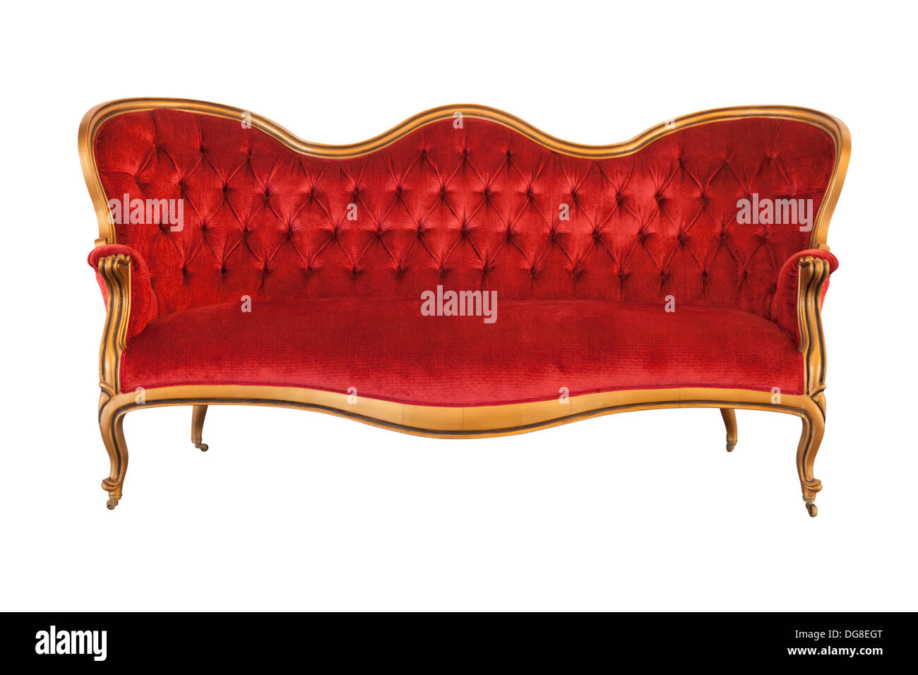 Old sofa with wooden frame, covered with red velvet Stock Photo