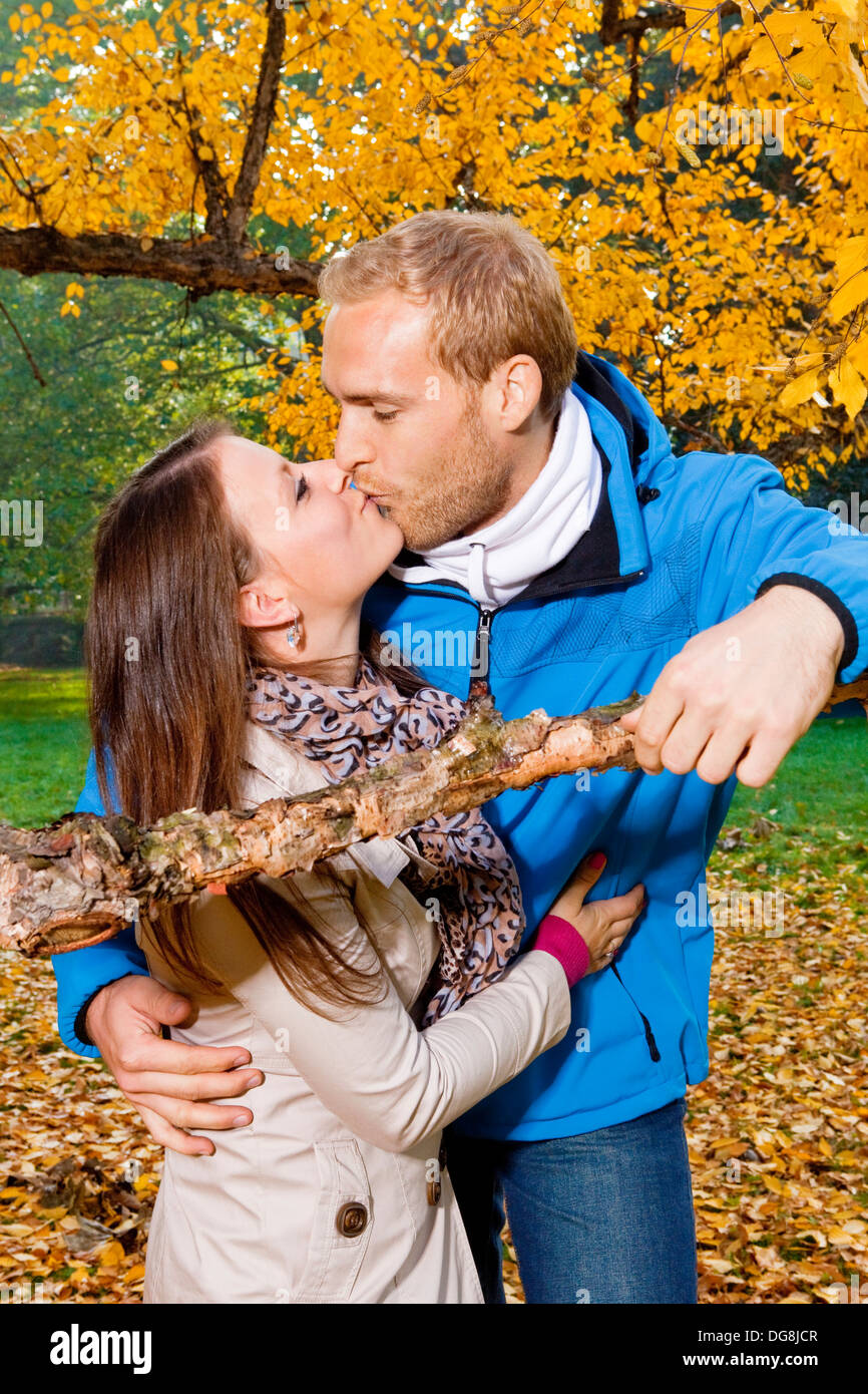 portrait of a happy young couple in the park, kissing. Stock Photo