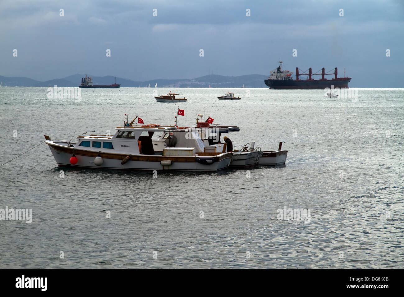 Local Fishing Boats Swaying on the Waves in Bosphorus on Against Cloudy Sky Stock Photo