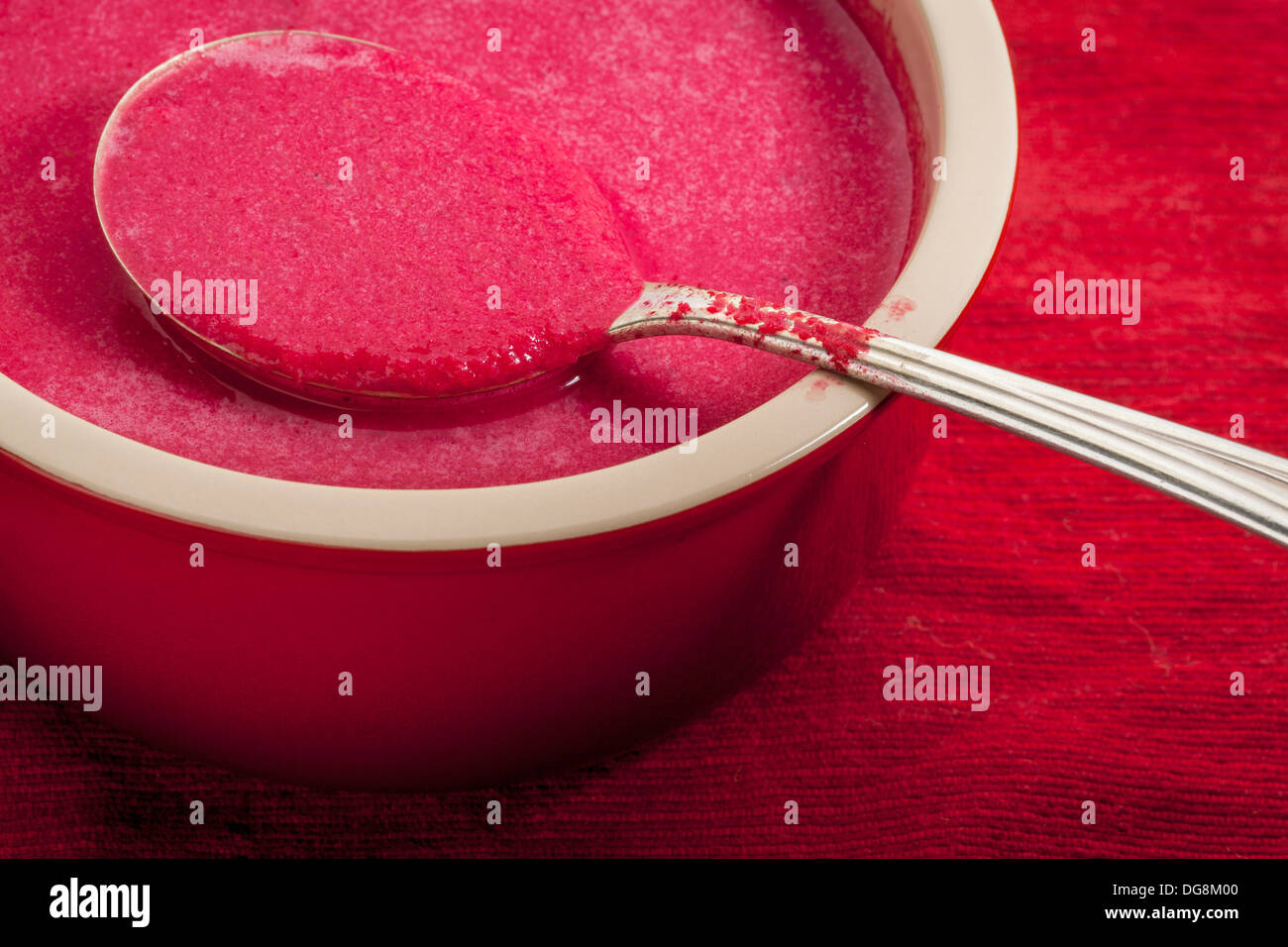 red beet cream soup in a stoneware bowl with a tablespoon Stock Photo