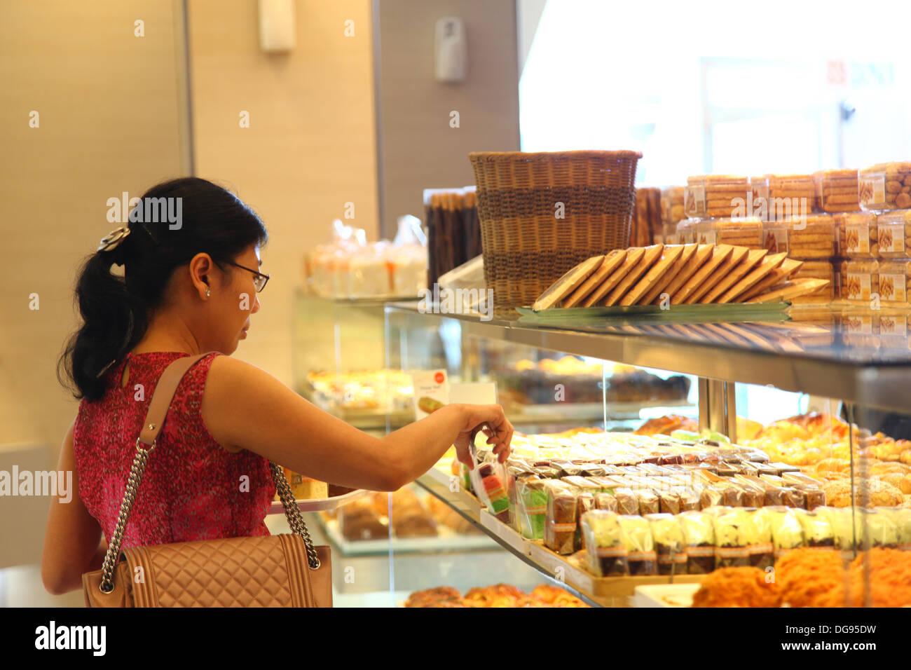Cilandak Town Square, Jakarta, Indonesia - October 12, 2013: A woman picks bread and pastry at BreadTalk Bakery in Cilandak Town Stock Photo