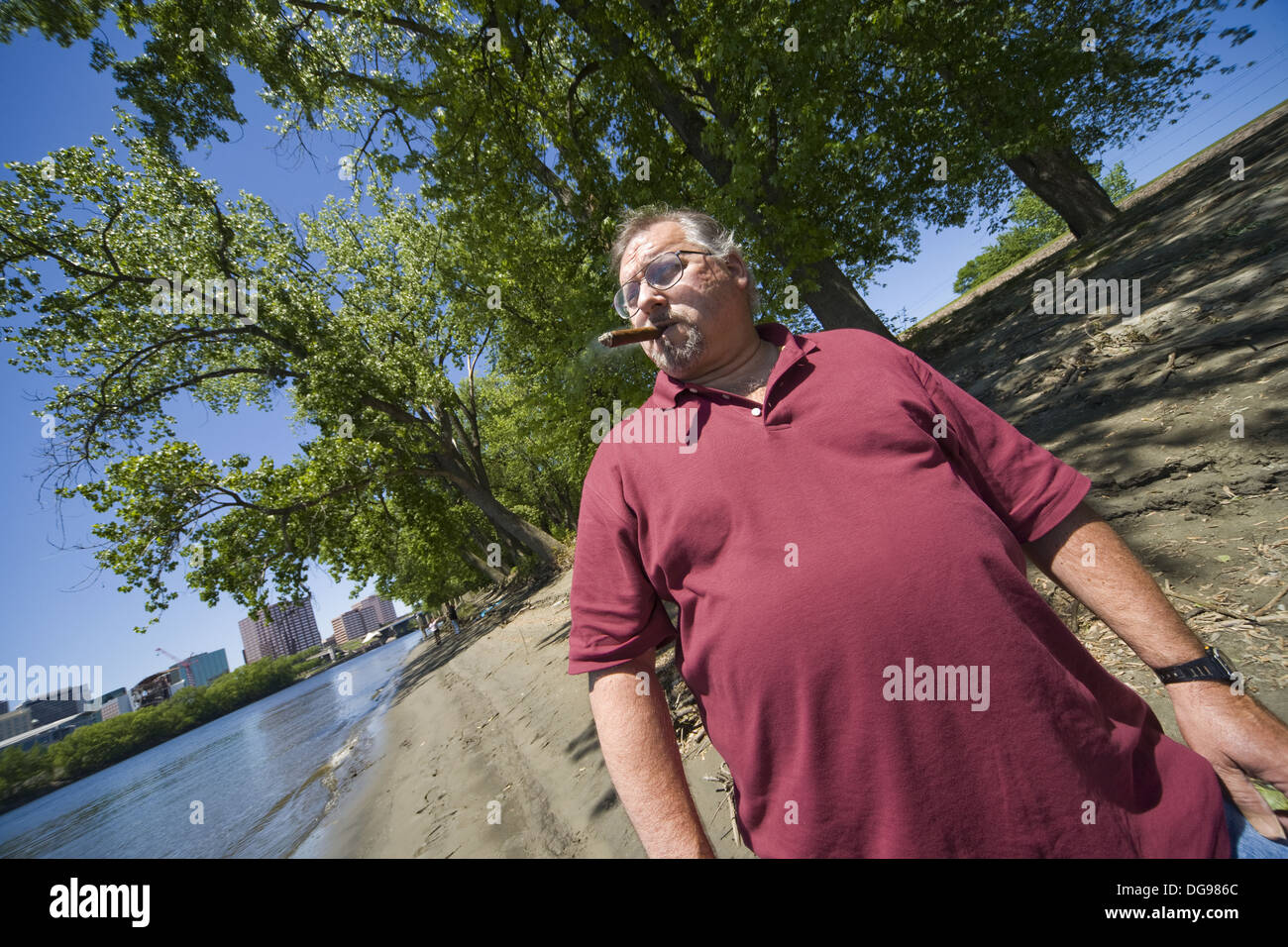 Middleage man standing by a river, smoking a cigar Stock Photo Alamy