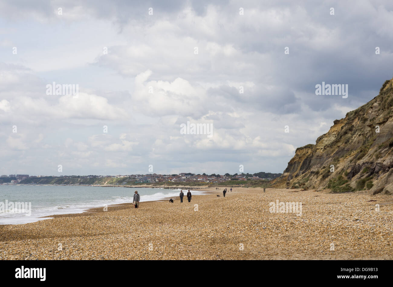 A typical scene on Hengistbury head beach with dog-walkers and hikers walking along the seaside. Holiday destination by the sea Stock Photo