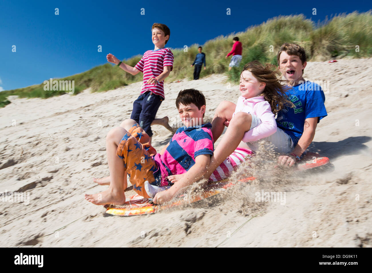 Children using body boards to slide down the sand dunes at Beadnell Stock Photo 61678093 Alamy