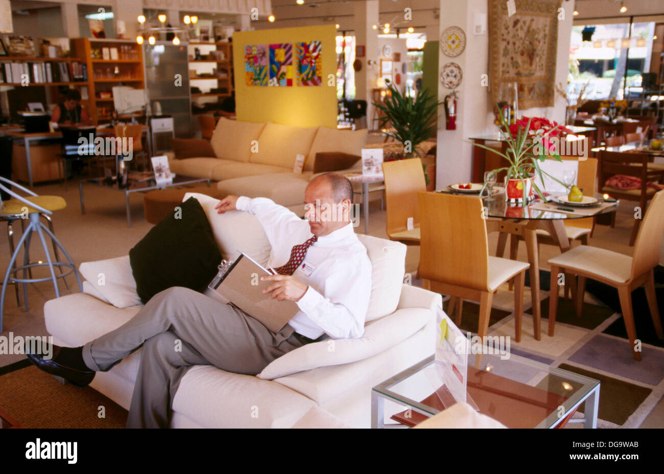 Salesman sitting on a sofa in a furniture store Stock Photo Alamy